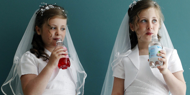 Twin sisters Aine (L) and Emer Quinn drink from bottles in the local parish hall after making their First Holy Communion in St. Mary's Roman Catholic Church, Cushendall, in this photo taken June 5, 2010. The reverence with which the Irish hold the Catholic Church had begun to fade even before the abuse scandals of recent years. As the economy boomed in the 1990s and 2000s, churches emptied. The abuse revelations have further undermined the Church's authority and fractured trust, alienating commi