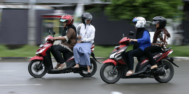 Acehnese women sit straddling on their motorcycles in Banda Aceh in Banda Aceh, Indonesia's Aceh province January 3, 2013. The administration of Lhokseumawe town, Aceh province, which is governed by Islamic Sharia law, is planning to issue a bylaw banning women from straddling motorcycles, arguing that the practice is improper for women, local media reported on Tuesday. REUTERS/Junaidi Hanafiah (INDONESIA - Tags: LAW TRANSPORT RELIGION)