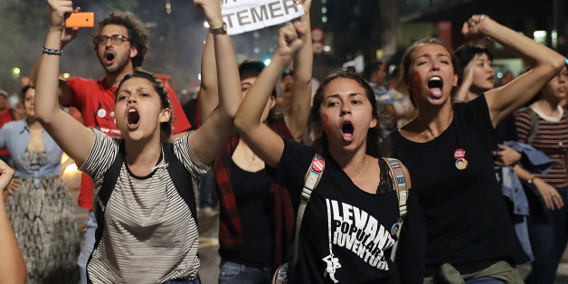 EDS NOTE GRAPHIC CONTENT - OBSCENE GESTURE - Demonstrators shout slogans against acting Brazil's President Michel Temer during a rally in support of Brazil's suspended President Dilma Rousseff in Sao Paulo, Brazil, Monday, Aug. 29, 2016. Police fired tear gas against the demonstrators. Fighting to save her job, Rousseff appeared before congress for her impeachment trial, to defend herself as her accusers say she hurt the economy with budget manipulations. (AP Photo/Andre Penner)