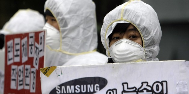 In this photo taken on March 25, 2010, South Korean activists, wearing protective clothing, participate in a rally near the Samsung semiconductor factory in Yongin, south of Seoul, South Korea, Thursday, July 15, 2010. Samsung Electronics said Thursday, July 15, 2010, it has commissioned an independent health and safety review of its semiconductor factories in South Korea after employee illnesses and deaths raised fears of cancer risks. (AP Photo/ Lee Jin-man)