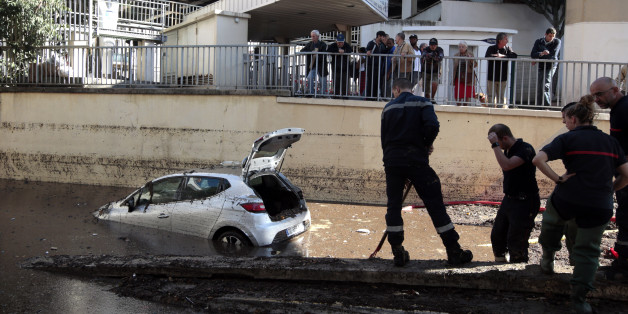French fireman work near an abandoned car stuck in muddy waters near an underpass after flooding caused by torrential rain in Cannes, France, October 4, 2015. Flooding along part of the French Riviera has killed at least 16 people, officials now said Sunday. The downpour hit the Alpes-Maritimes region, which lies at the eastern end of France's Mediterranean coast and borders Italy, on Saturday evening. REUTERS/Eric Gaillard ATTENTION EDITORS FRENCH LAW FORBIDS THE PUBLICATION OF AUTOMOBILE REGISTRATION PLATES IN PUBLICATIONS WITHIN FRANCE