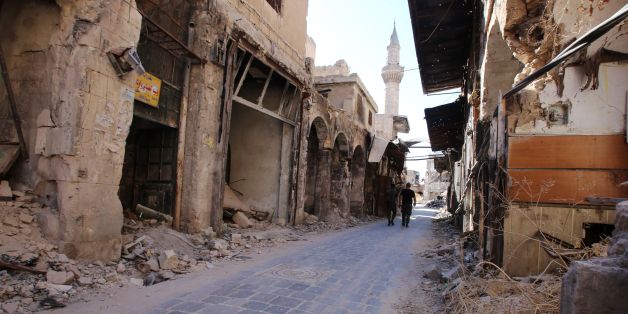 Syrian government soldiers walk in the damaged al-Farafira souk in the government-held side of Aleppo's historic city centre on September 16, 2016.Violence broke out in Aleppo in mid-2012, more than a year after anti-government protests first erupted across Syria.More than five years of war have turned Aleppo's historic city centre, a UNESCO-listed World Heritage site home to an imposing citadel, into a makeshift military barracks. / AFP / Youssef KARWASHAN (Photo credit should read YOUSS