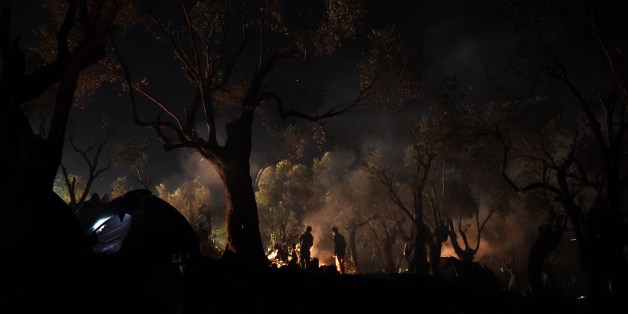 Refugees and migrants spend the night in a field outside of the Moria Hot Spot, on the Greek island of Lesbos on November 9, 2015. More than 3,000 refugees and migrants have drowned among the nearly 800,000 who have reached Europe this year. However, EU states have bickered for months over a joint solution, particularly over plans to relocate a total of 160,000 asylum seekers from frontline countries to other parts of the EU bloc. AFP PHOTO / ARIS MESSINIS (Photo credit should read ARIS MESSINIS/AFP/Getty Images)