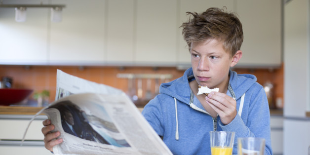 DUELMEN, GERMANY - AUGUST 13: Fourteen-year-old boy reading the newspaper at the breakfast table on August 13, 2014, in Duelmen, Germany. Photo by Ute Grabowsky/Photothek via Getty Images)***Local Caption***