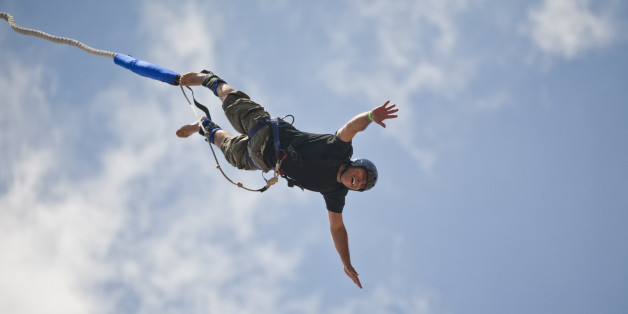 Bungee jumping man against sky.