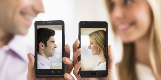 Couple holding smartphones with their pictures on