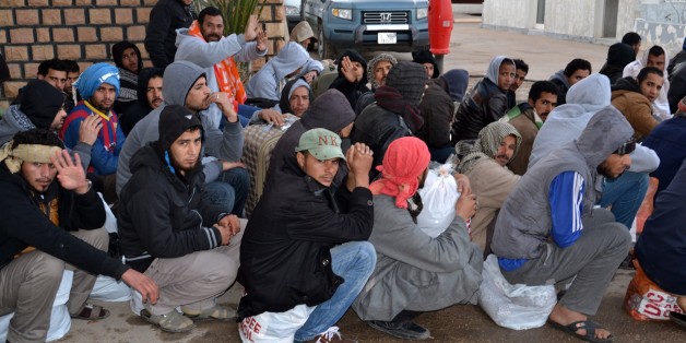 Egyptian workers wait after having crossing the Tunisian border at the Ras Jdir border crossing between Libya and Tunisia, Friday, Feb. 20, 2015. A group of almost 200 Egyptians have crossed into Tunisia from Libya, the first of thousands expected to flee the turmoil in the country. The execution of 21 Egyptian Christians by extremists and retaliatory Egyptian airstrikes has prompted many Egyptians to want to leave Libya. Authorities said 192 Egyptians went through the Ras Jdir border crossing Friday and headed to the Djerba airport where they will fly back to Cairo. (AP Photo/Ali Manssour)