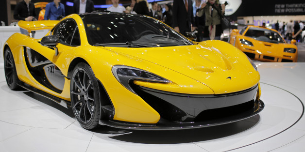People look at the new McLaren P1 during the 83rd Geneva International Motor Show, Switzerland, Monday, March 4, 2013. The Motor Show will open its gates to the public from March 7 to 17. (AP Photo/Laurent Cipriani)