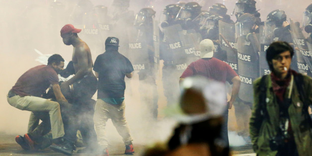 People maneuver amongst tear gas in uptown Charlotte, NC during a protest of the police shooting of Keith Scott, in Charlotte, North Carolina, U.S. September 21, 2016. REUTERS/Jason Miczek