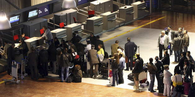 Travellers queue at an airline check-in counter at Nice International Airport in southern France April 18, 2010. The airport has cancelled all flights on Sunday except for two flights travelling to Tunis and Marrakech due to a cloud of smoke from an Icelandic volcano. French airports north of a line between Nice and Bordeaux will remain closed until at least Tuesday morning, Prime Minister Francois Fillon said on Sunday. REUTERS/Regis Duvignau (FRANCE - Tags: TRANSPORT DISASTER)