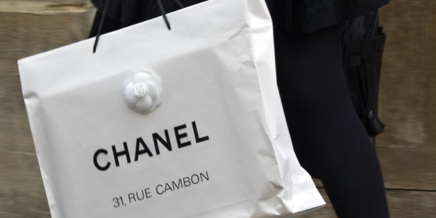 A woman walks with a shopping bag from fashion house Chanel in central Paris October 13, 2008. REUTERS/Charles Platiau (FRANCE)