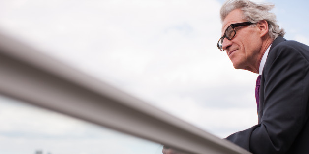 Businessman leaning on balcony railing
