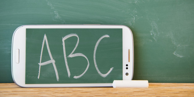 Smartphone leaning against chalkboard with ABC letters displayed