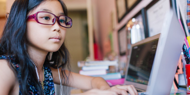 Young girl sitting in front of laptop