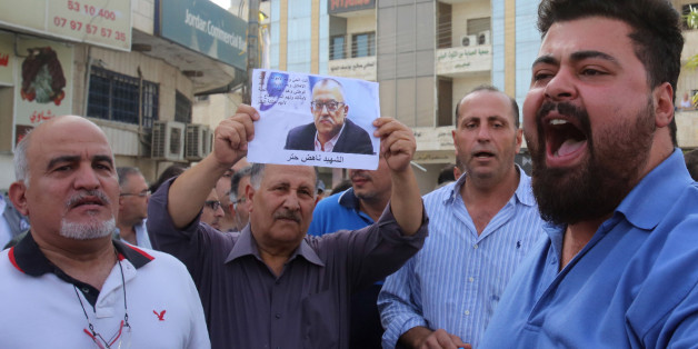 Demonstrators shout slogans during a demonstration in the town of Fuheis, 20km northwest of the capital Amman on September 25, 2016, denouncing the killing of prominent Jordanian writer Nahed Hattar (portrait).Hattar was shot dead on the steps of a court where he was facing charges for sharing an anti-Islam cartoon online, in an attack condemned as 'heinous'.Nahed, a 56-year-old Christian, was struck by three bullets before the alleged assassin was arrested at the scene of the shooting in Amman'