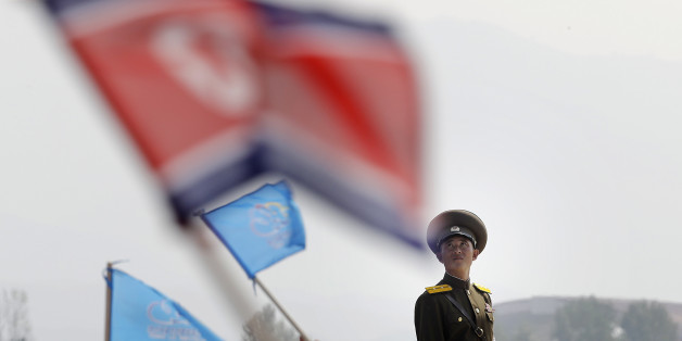In this Sept. 24, 2016 file photo, a North Korean military soldier stands guard as North Koreans wave flags and cheer during an aerial display, in Wonsan, North Korea. North Korea on Saturday opened an air festival featuring sky diving, demonstrations by its air force and lots of beer to promote a newly renovated and upgraded commercial airport in the coastal city of Wonsan that it hopes will draw for foreign tourists. (AP Photo/Wong Maye-E, File)