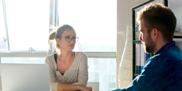 Two young people having discussion in office