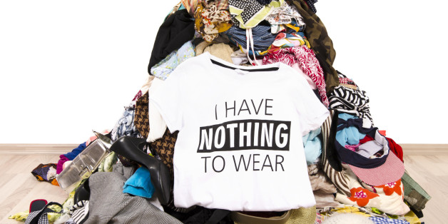 Big pile of clothes thrown on the ground with a t-shirt saying nothing to wear. Close up on a untidy cluttered wardrobe with colorful clothes and accessories,