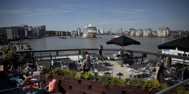People look out from a restaurant roof terrace as the Viking Sea cruise ship docks at Greenwich in London, Thursday, May 5, 2016. The vessel, owned by Viking Sea, arrived in London Thursday for its naming ceremony in Greenwich where it will be the largest ocean ship to be christened on the River Thames. (AP Photo/Matt Dunham)