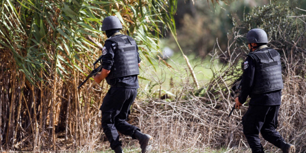 Members of the Tunisian National Guard take positions as they secure the scene of a shooting in the Oued Ellil suburb of Tunis, Tunisia, Thursday, Oct. 23, 2014. A Tunisia official says a security officer has been killed in a shootout that began when a suspect's home was surrounded near the capital. Interior Ministry spokesman Mohammed Ali Aroui says the exchange of fire Thursday came after a pair of counterterrorism operations in the south that left one bystander dead. (AP Photo/Aimen Zine)