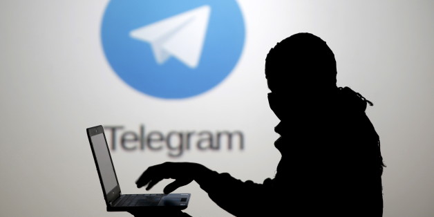 Un homme pose devant un écran montrant le logo de l'application Telegram