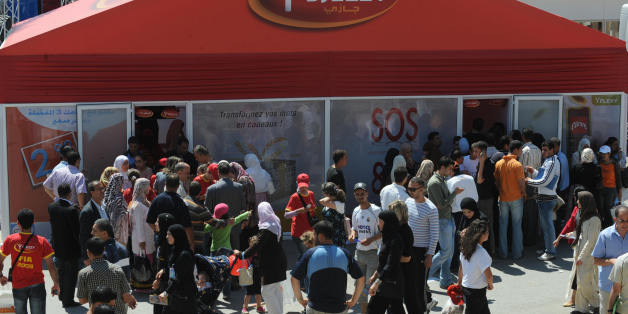 TO GO WITH AFP STORY BY HAMID GUEMACHE Algerian customers queue at the entrance of a 'Djezzy Telecom' office during the 40th Algerian International Exhibition (SAFEX) on June 12, 2008 in Algiers. Algerian authorities began a vast campaign since February of telephone identification SIM cards in order to curb non-legal trafficking, regulate the market and fight terrorism. AFP PHOTO/FAYEZ NURELDINE (Photo credit should read FAYEZ NURELDINE/AFP/Getty Images)