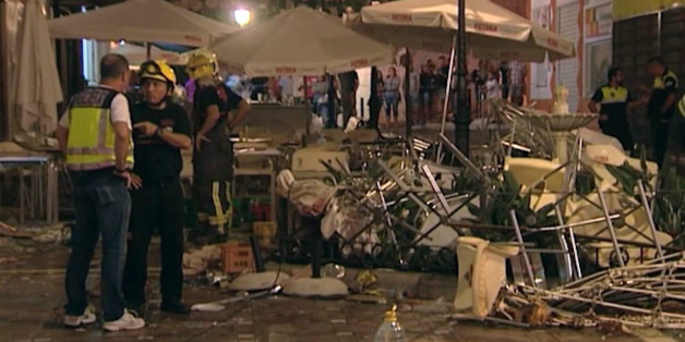 In this grab taken from video, provided by Wikono, emergency services stand outside the cafe La Bohemia, after an explosion, in Malaga, Spain, Saturday, Oct. 1, 2016. More than 70 people have been injured in a gas cylinder explosion near the southern Spanish city of Malaga, according to the local media. (Wikono via AP)