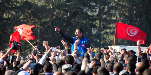 Hundred of police officers shouts slogans as they demonstrate outside the presidential palace in Carthage near Tunis, Tunisia, to demand a pay increase, Monday, Jan. 25, 2016. Tunisian Prime Minister Habib Essid has pleaded for "patience" following a wave of violent demonstrations against poverty and unemployment, the worst social unrest since the 2011 revolution. (AP Photo/Riadh Dridi)