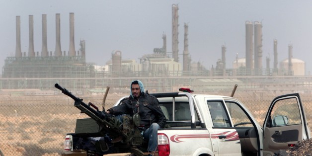 FILE - In this March 5, 2011 file photo, an anti-government rebel sits with an anti-aircraft weapon in front an oil refinery in Ras Lanouf, eastern Libya. The United States France, Germany, Italy, Spain and Britain have called upon forces loyal to a Libyan general to withdraw from three eastern oil terminals seized earlier this week, in a statement Monday, Sept. 13, 2016. The oil-rich North African country slid into chaos after the 2011 uprising that toppled and killed Moammar Gadhafi. (AP Photo/Hussein Malla, File)