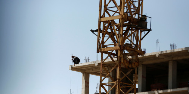 A worker looks down from the top of a new apartment building being built at a construction site in Algiers, Algeria May 3, 2016. REUTERS/Zohra Bensemra