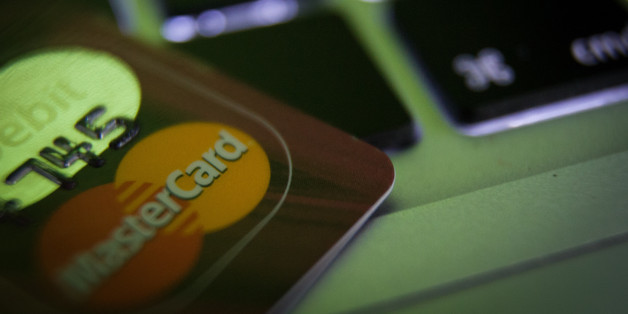 A debit card is seen on a laptop computer keyboard with binary numbers reflected in its hologram, in Bydgoszcs, Poland, on August 7, 2016. (Photo by Jaap Arriens/NurPhoto via Getty Images)