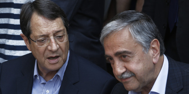 Cyprus President Nicos Anastasiades, left, and Turkish Cypriot leader Mustafa Akinci, speak as they sit at a coffee shop at the Turkish Cypriot breakaway northern part of the Cypriot divided capital Nicosia on Saturday, May 23, 2015. Cyprusâ rival Greek and Turkish Cypriot leaders took a stroll together on both sides of the divided capitalâs medieval center to raise the feel-good factor as talks aimed at reunifying the ethnically split island kick into gear. Itâs the first time that the leaders have done so together since the east Mediterranean island was split in 1974 when Turkey invaded after coup by supporters of union with Greece. (AP Photo/Petros Karadjias)