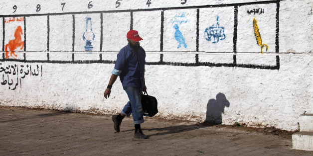 A man walks past a wall marked by the numbers of districts where civilians should go to vote, in Rabat November 18, 2011. Morocco will hold parliamentary elections on November 25. REUTERS/Stringer (MOROCCO - Tags: ELECTIONS POLITICS)