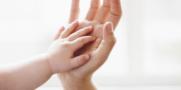 Baby touching mother's hand