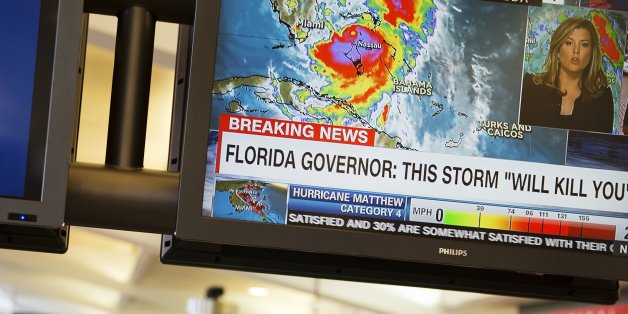 A monitor shows a television news report on Hurricane Matthew as travelers collect their baggage after arriving at Hartsfield-Jackson Atlanta International Airport in Atlanta, Thursday, Oct. 6, 2016. Airlines canceled hundreds of flights for Thursday and again Friday as Hurricane Matthew pelted the Florida coast with high winds and heavy rain. (AP Photo/David Goldman)