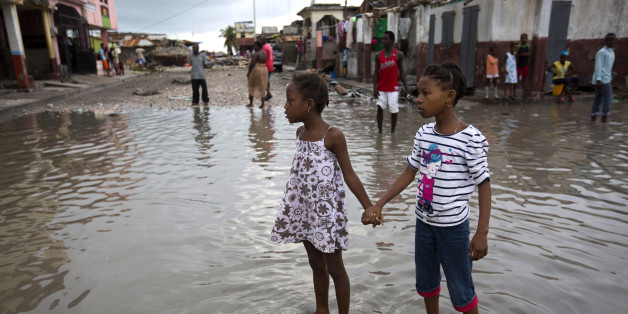 Girls hold hands as they help each other wade through a flooded street after the passing of Hurricane Matthew in Les Cayes, Haiti, Thursday, Oct. 6, 2016. Authorities and aid workers fear the storm is the country's biggest disaster in years (AP Photo/Dieu Nalio Chery)