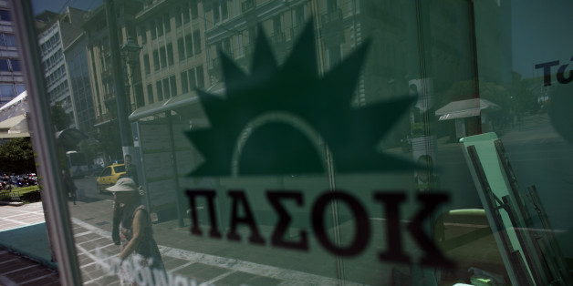 A woman is reflected on a window as she approaches an election kiosk of Greece's Socialist party (PASOK) one day before general elections in Athens, Saturday, June 16, 2012. The sticker reads "self-reliant Greece" . Greeks vote for the second time in six weeks Sunday amid fears that the country could be forced out of the euro if they reject the strict austerity measures taken in return for billions of euros in rescue loans from other European countries and the International Monetary Fund. (AP Photo/Kostas Tsironis)