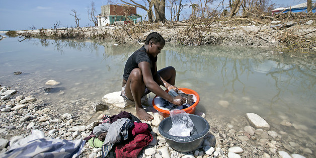 Natalie Joseph cleans clothes in a river cutting through Roche a Bateau, Haiti on Sunday, Oct. 9, 2016. (Patrick Farrell/Miami Herald/TNS via Getty Images)