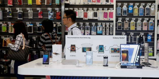 Customers queue beside Galaxy Note 7 smartphone advertisements at Samsung service centre in Taipei, Taiwan October 11, 2016. REUTERS/Tyrone Siu