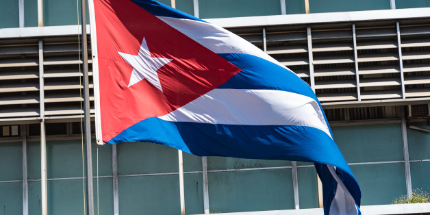 HAVANA CITY, HAVANA, CUBA - 2015/09/19: Cuban flag in pole with building design in the background.The flag of Cuba consists of five blue and white alternating stripes, and a red equilateral triangle at the hoist with a white five-pointed star. (Photo by Roberto Machado Noa/LightRocket via Getty Images)
