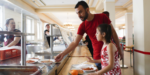 Syrian refugee Moustafa Shikh Habib and his daughter Noor take some food in the refugee shelter where they live on the first day of the Islamic holiday of Eid al-Fitr the end of the fasting month of Ramadan, in Berlin, Germany, Tuesday, July 5, 2016. âItâs difficult to be away from all the family, from my brothers, on this special day,â the 36-year-old Kurd Moustafa said at his new home in Berlin, two little cramped rooms he shares with his family. (AP Photo/Markus Schreiber)