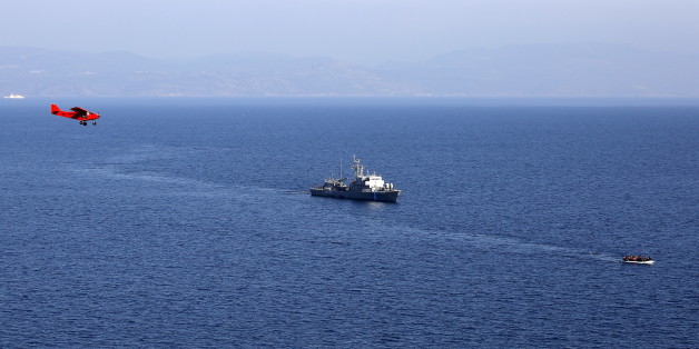 A raft overcrowded with migrants and refugees is followed by a Frontex plane and a Greek Coast Guard vessel near a beach on the Greek island of Lesbos November 19, 2015. Balkan countries have begun filtering the flow of migrants to Europe, granting passage to those fleeing conflict in the Middle East and Afghanistan but turning back others from Africa and Asia, the United Nations and Reuters witnesses said on Thursday. REUTERS/Yannis Behrakis