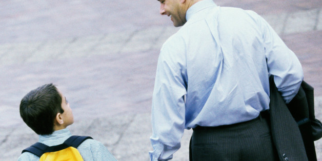 Rear view of a father and his son holding hands