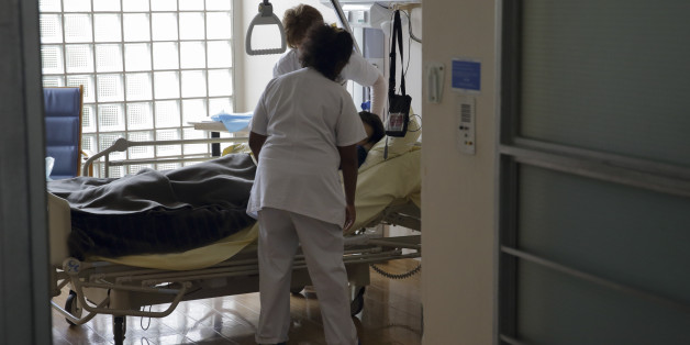 Nurses provide care to a patient at the palliative care unit of the AP-HP Paul-Brousse Hospital in Villejuif near Paris March 4, 2015. France's parliament will on Tuesday debate a bill allowing patients near the end of their lives to stop treatment and enter a "deep sleep" until they die, a move that critics say amounts to euthanasia in disguise. If passed, the legislation would give dying patients in the secular but majority Catholic country more power over their own treatment. Jean Leonetti, a centre-right lawmaker and doctor who authored the law, told Reuters the bill would allow patients with "hours or days to live" to request to be placed under general anaesthetic right through to the moment they die. Picture taken March 4, 2015. REUTERS/Philippe Wojazer (FRANCE - Tags: SOCIETY POLITICS HEALTH)