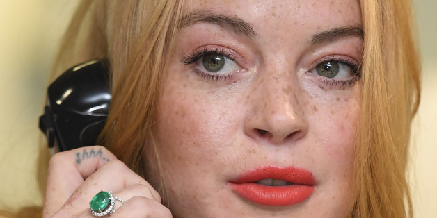 U.S. actress Lindsay Lohan speaks on a telephone as dealers work on a trading floor during a charity day at BGC Partners in the Canary Wharf business district in London, Britain September 12, 2016. REUTERS/Toby Melville TPX IMAGES OF THE DAY