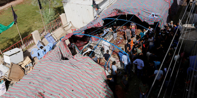 People gather at the site of a suicide bomb attack in the city's northern al-Shaab district in Baghdad, Iraq October 15, 2016. REUTERS/Ahmed Saad