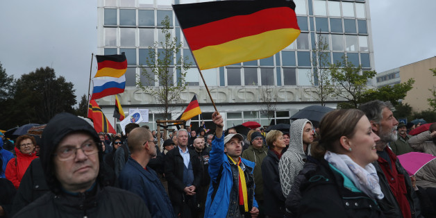 DRESDEN, GERMANY - OCTOBER 03: Supporters of the Pegida movement, including some waving German flags, listen to speeches after marching on German Unity Day on October 3, 2016 in Dresden, Germany. Unity Day, called Tag der Deutschen Einheit, commemorates German reunification of East and West Germany following the end of the Cold War. This year's main celebrations are taking place in Dresden and are being accompanied by protests from both left and right-wing groups, notably the anti-Muslim and an