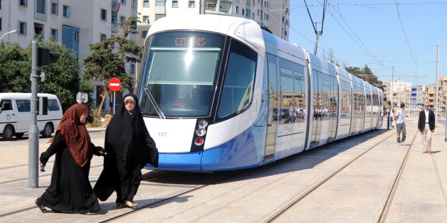 Women cross in front of a new tramcar on May 8, 2011 in Algiers. After a two-year delay, the new tramway service opened, starting with a 7.2 km section running between Bordj El Kiffan and Bab-Ezzouar, serving residents in the densely populated eastern part of the city. AFP PHOTO / FAROUK BATICHE (Photo credit should read FAROUK BATICHE/AFP/Getty Images)