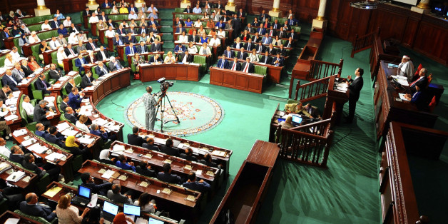 Newly named Tunisian Prime Minister Youssef Chahed, standing at right, delivers his speech at the Parliament in Tunis, Friday Aug. 26, 2016 ahead of a confidence vote. Chahed, 41, was minister for local affairs in the government of Habib Essid that fell last month. (AP Photo/Riadh Dridi)