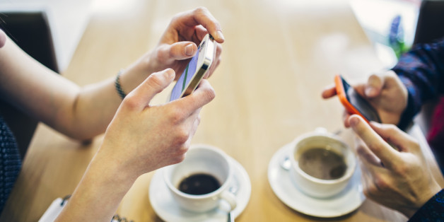 Two teenagers using smart phones